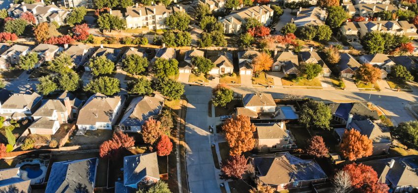 Aerial view Valley Ranch planned unit development in suburbs Dallas, Texas. Flyover sprawl subdivision in fall season with colorful foliage laves and row of single-family houses community