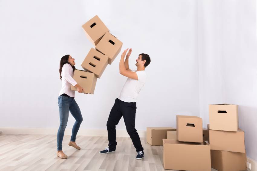 Woman carrying boxes that are falling