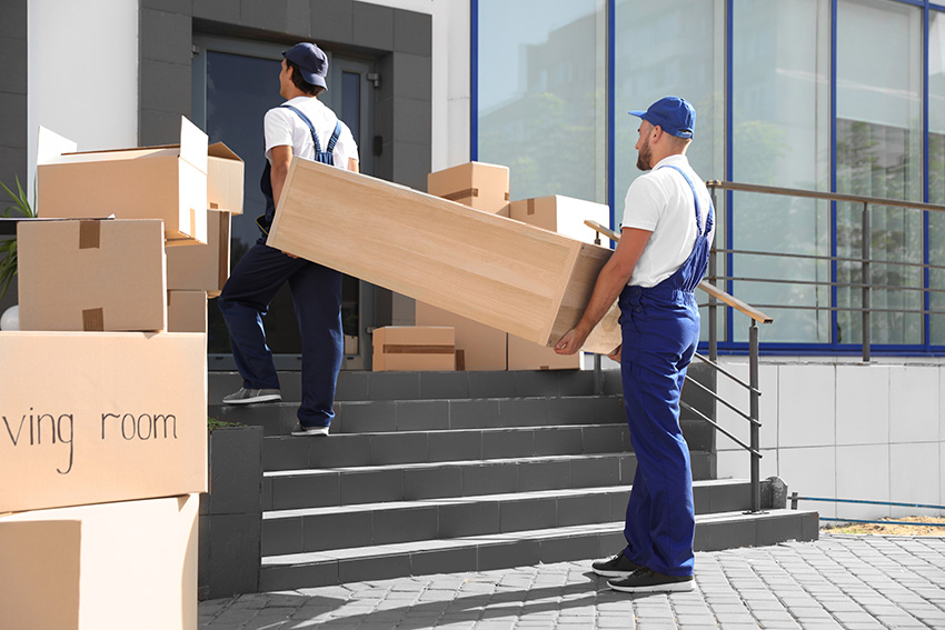 Movers taking furniture inside residence