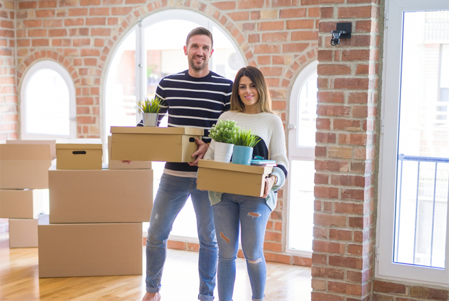 a couple unpacking and arranging a home