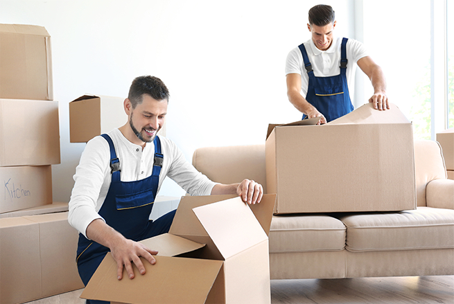 Two men unpacking boxes in a living room