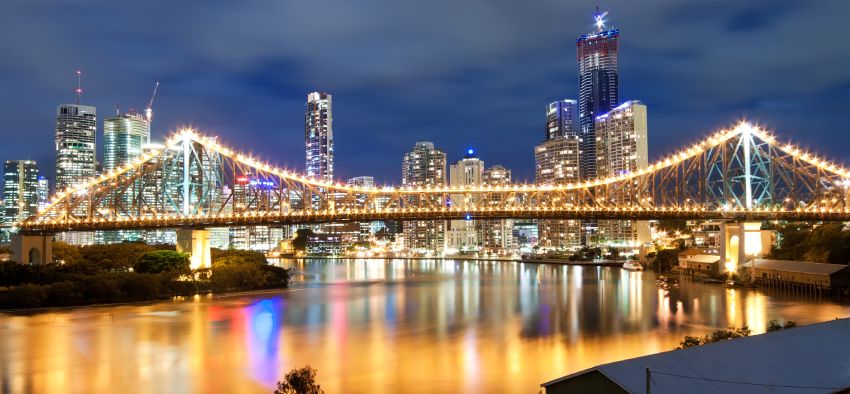 view on interesting modern bridge at night with city skyline in the background