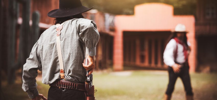ฺBackside view of cowboy while standing gun prepares on gunfight in cowboys village is cowboy western lifestyle concept.