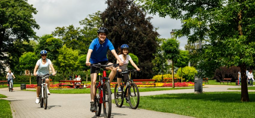 Healthy lifestyle - people riding bicycles in city park