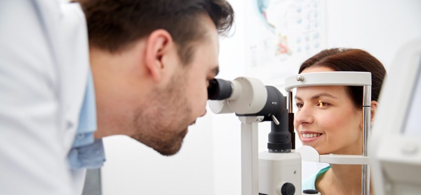 optician with tonometer and patient at eye clinic