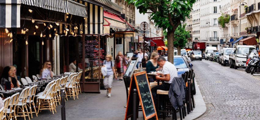 Cozy street with tables of cafe in quarter Montmartre in Paris, France. Architecture and landmarks of Paris. Postcard of Paris