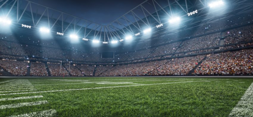 Dramatic 3D professional American football arena with green grass and rays of light