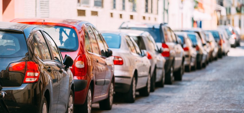 Cars Parked On Street In European City In Sunny Summer Day. Background