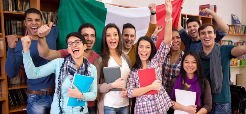 Smiling students with raised hands presenting Italy with flag