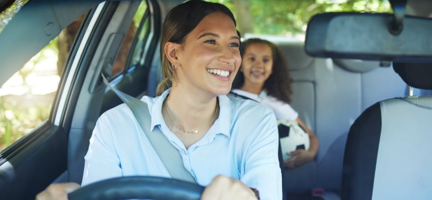 Travel, mother and child in car for drive, fun and sports, soccer and adventure, happy and excited. Mom, driver and girl passenger in vehicle, smile and bonding on road trip to football activity