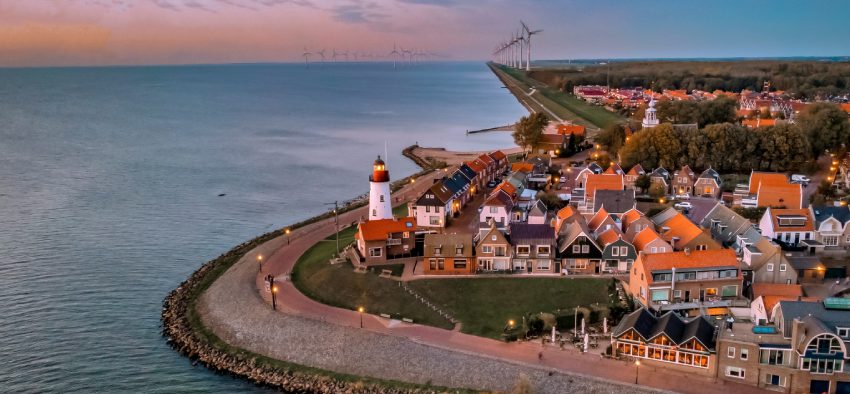 Urk Flevoland Netherlands sunset at the lighthouse and harbor of Urk Holland. Traditional Fishing village Urk. Beautiful sunset during the evening